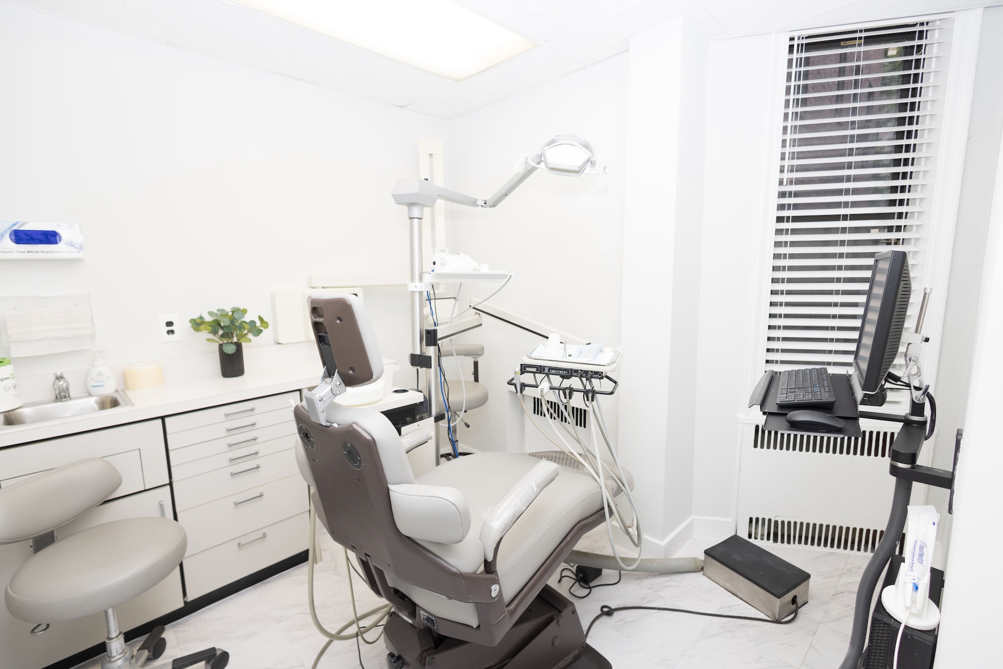 The image shows an interior view of a dental office, featuring dental chairs and equipment.