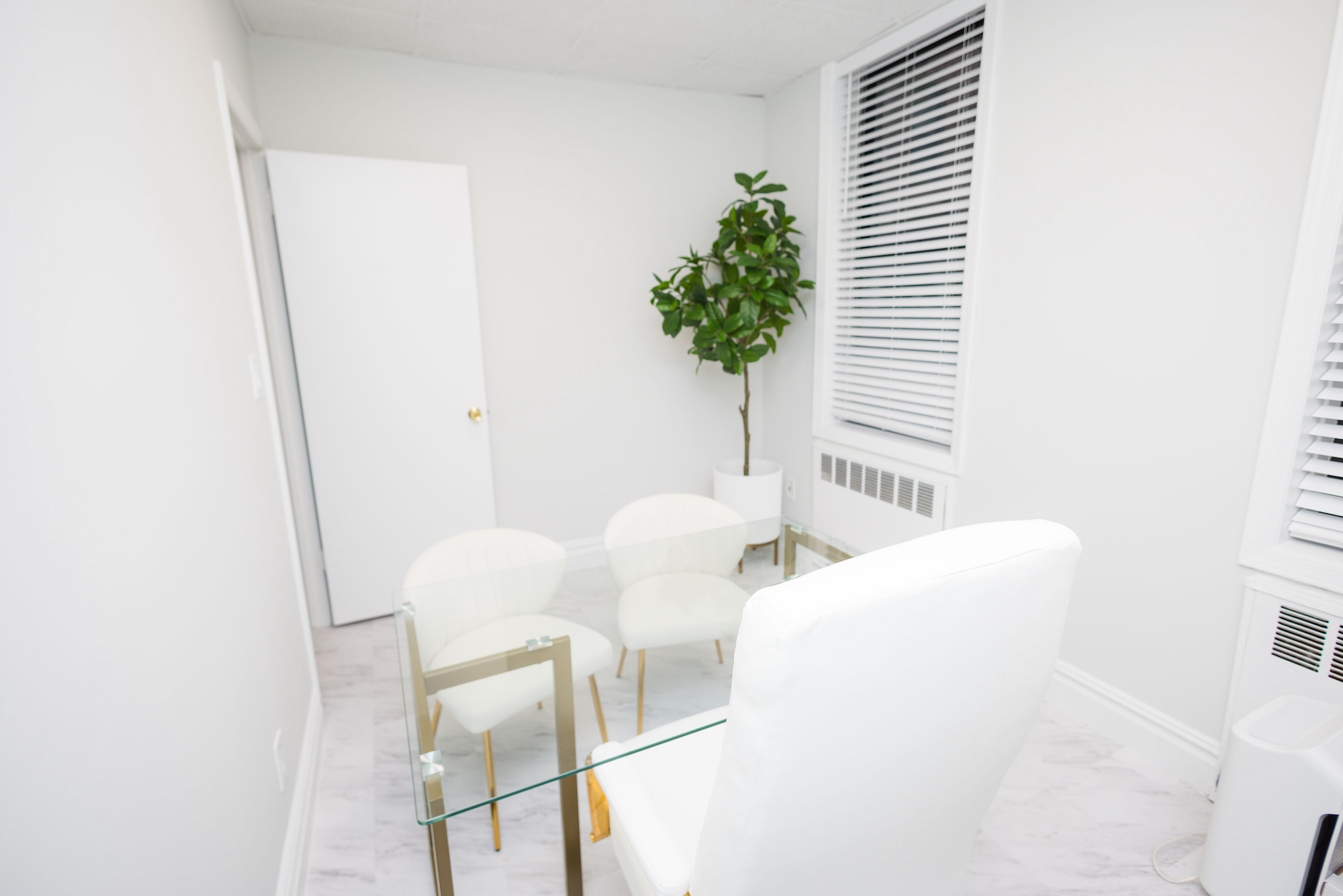 A modern, well-lit living room with a white sofa and a glass coffee table.