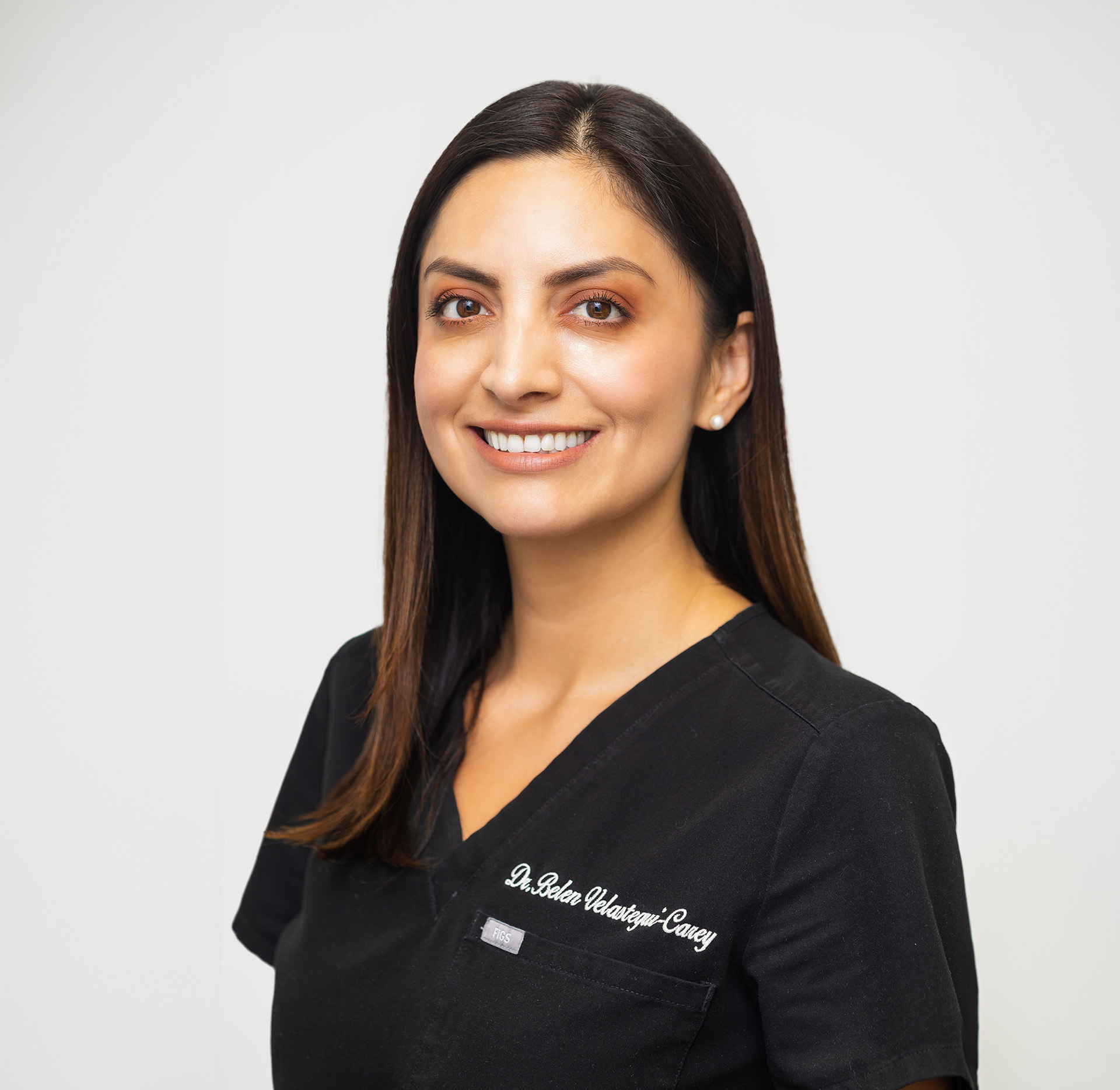 A woman in a dental office, smiling and posing for the camera.