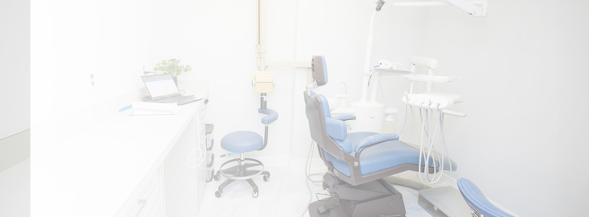 The image is a photograph of an interior space that appears to be a dental or medical office, featuring a clean and organized environment with chairs, a desk, and equipment typically associated with healthcare.