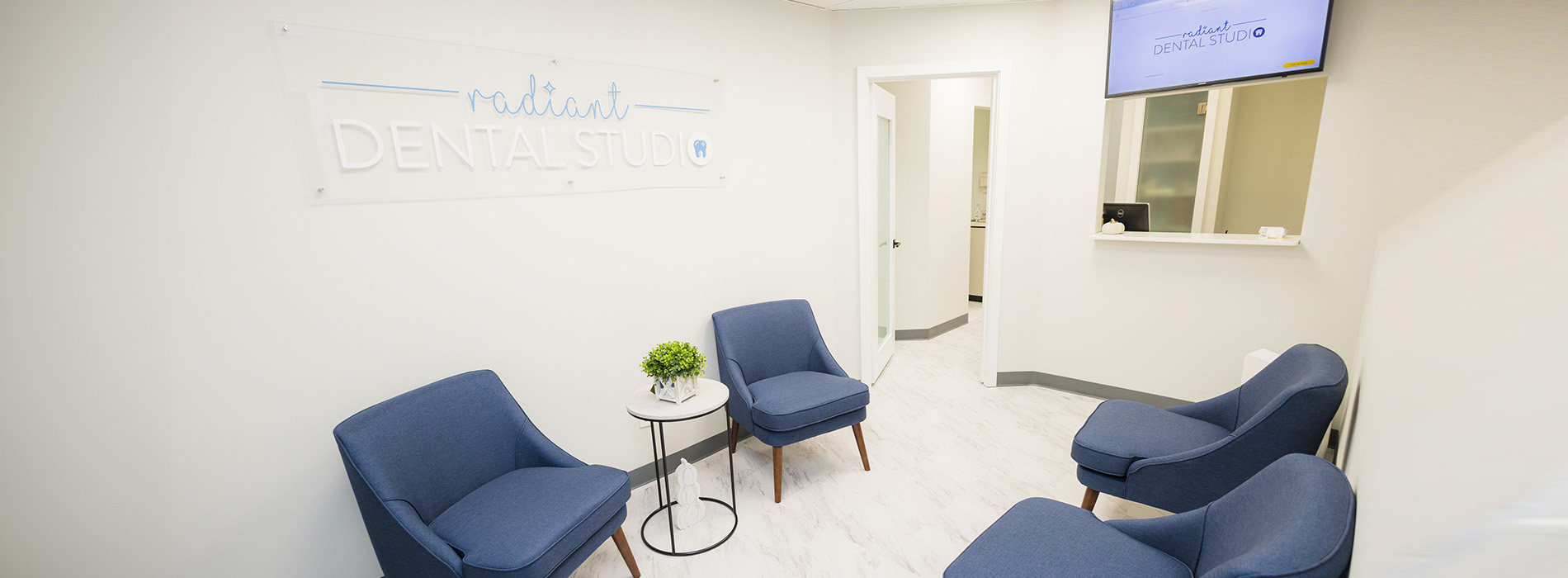 A modern dental office interior with a waiting area featuring blue furniture and a reception desk.