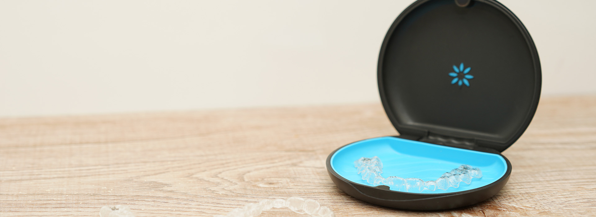 A small, blue circular object with a white logo on top of a wooden surface.