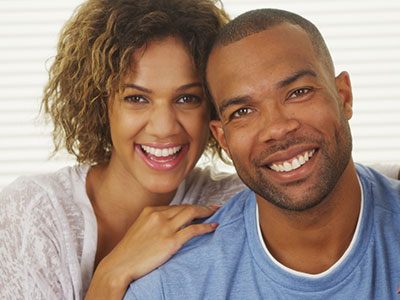 A man and a woman are smiling and posing for a photograph together.